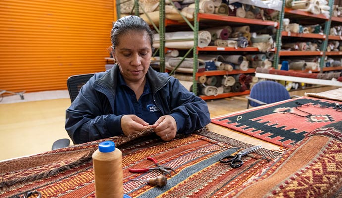 An expert of Dalworth Rug Cleaning repairing a damaged rug