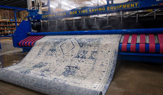 A professional rug cleaning process using an industrial machine to remove dirt