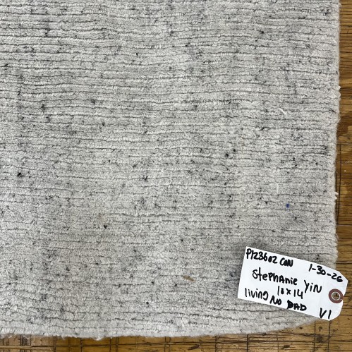 Close-up of a cleaned residential rug texture with a service tag indicating customer name, dimensions, and job details by Dalworth Rug Cleaning