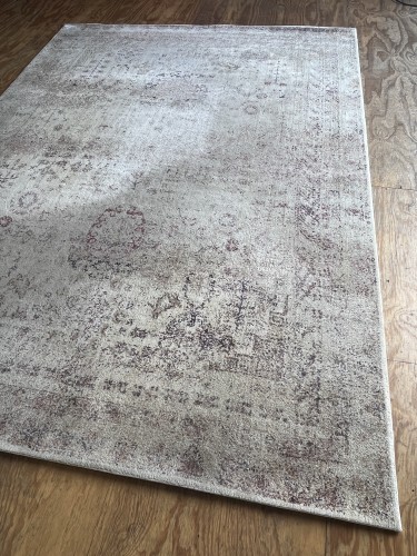 A large contemporary distressed area rug in elegant cream, grey, and faded burgundy shades, completely deep-cleaned, sanitised for pet odours, and pile-restored on a wooden floor.
