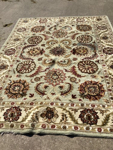 Expert residential rug cleaning and restoration service repairing torn areas and holes in an ornate rug.