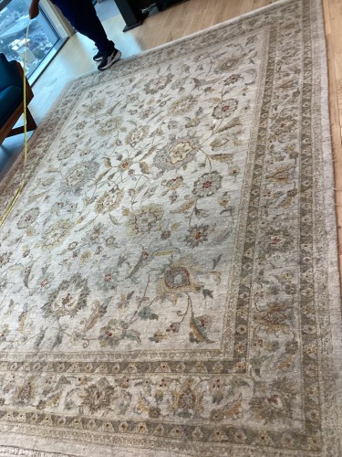 A large traditional floral area rug in elegant ivory, sage green, and tan shades, completely deep-cleaned, sanitised for pet odours, and steam-restored to eliminate furniture marks on a hardwood floor.