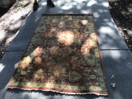 Professional rug cleaning service treating white knots, moderate soil, and furniture marks on a patterned rug.