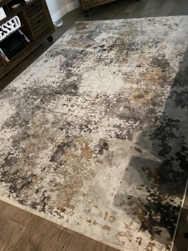 Residential area rug after professional cleaning by Dalworth Rug Cleaning, featuring a modern abstract pattern in white, grey, brown, and black, placed on a hardwood floor.