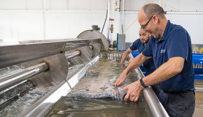 Experts cleaning rugs using advanced machines